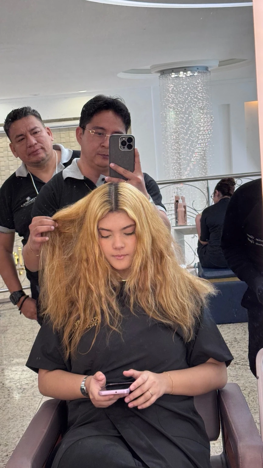 Antes de Color Solution: vista frontal de cabello rubio con raíces oscuras en el salón.